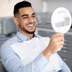 Man smiling at reflection in mirror in treatment chair