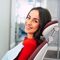 Woman in red shirt smiling in treatment chair
