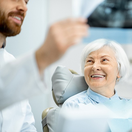 Dentist explaining an X-ray to an older patient.