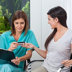 A woman paying the cost of cosmetic dentistry