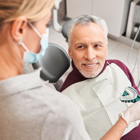 A dentist showing a patient denture impressions 