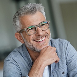 man with glasses smiling with confidence