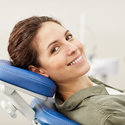 Woman in dentist’s chair smiling after an extraction  