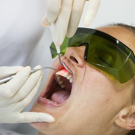 A woman receiving soft tissue laser therapy.