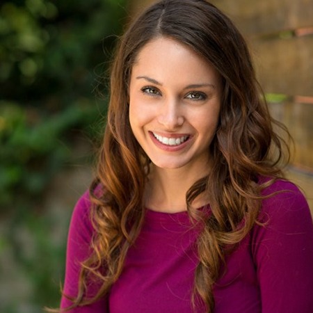 A woman smiling outside.