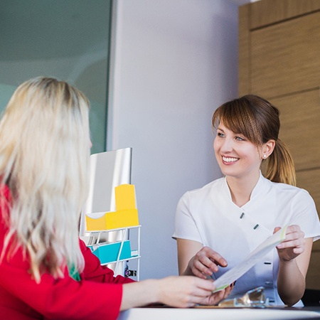 dental team member showing a paper to a patient