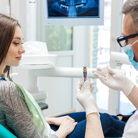 dentist showing a patient how dental implants work