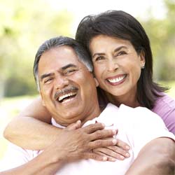 Older couple with dental implants in Savannah smiling outside