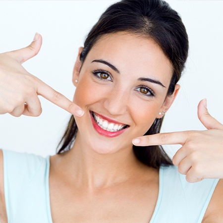 Woman pointing to her smile