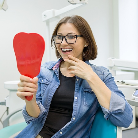 Woman looking at smile in mirror