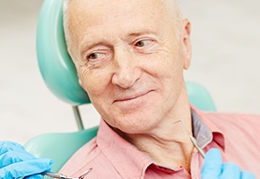 Older man in dental chair smiling