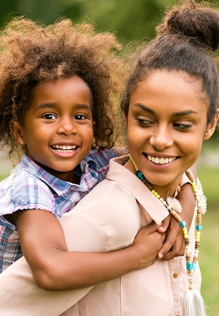 Smiling mother and daughter outdoors