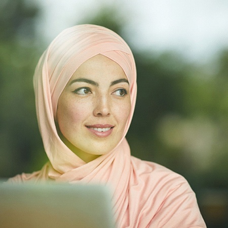 a person smiling while looking out of a coffee shop window