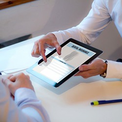 Dentist and patient discussing dental insurance with an electronic reader