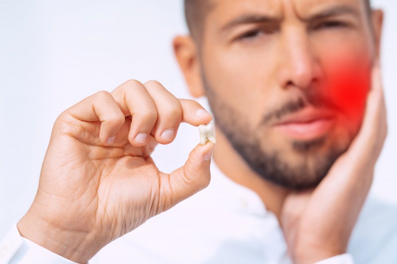 A man feeling pain after a wisdom tooth extraction