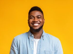 man smiling in front of a yellow background