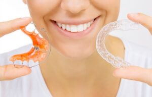 Woman holding 2 retainers.